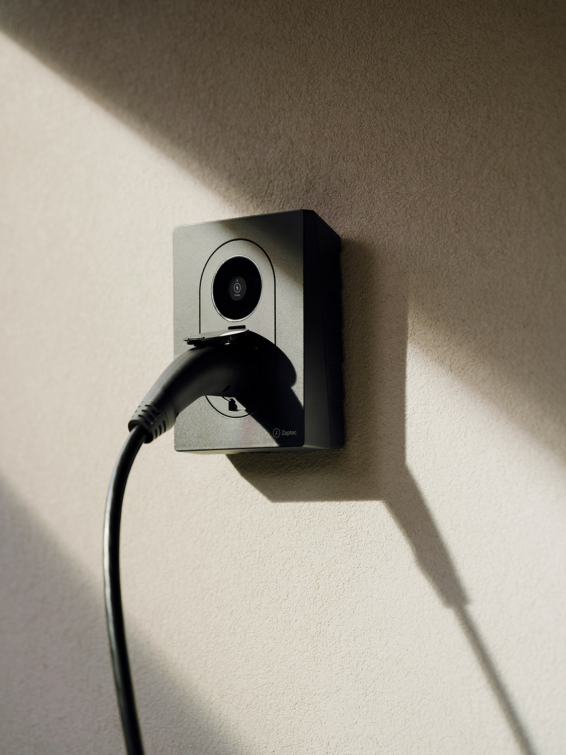 Zaptec Go 2 montert på en husvegg i sol, klar til hjemmelading av elbil
